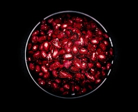Close-up of vibrant fruit pulp in a rustic wooden bowl on a clean white background.