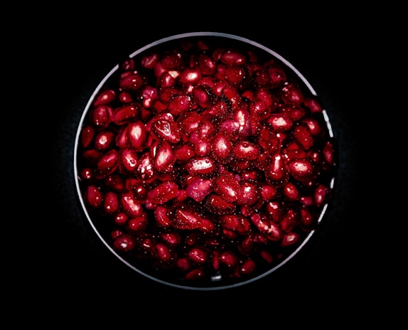 Close-up of vibrant fruit pulp in a rustic wooden bowl on a clean white background.