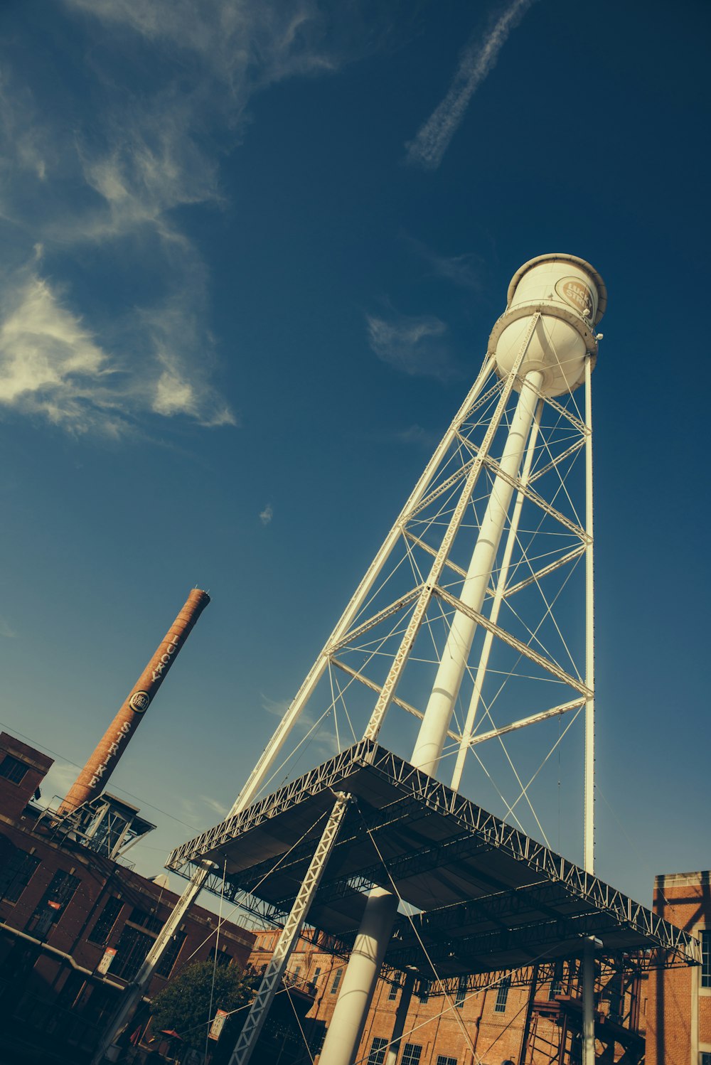 a tall white water tower sitting next to a building