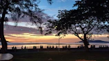 A colorful sunset backdrop framing families sharing smiles and creating memories outdoors.