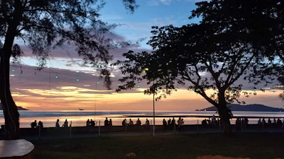 A colorful sunset backdrop framing families sharing smiles and creating memories outdoors.