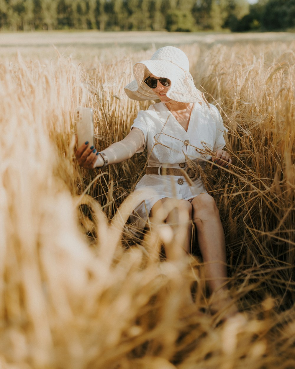 a woman sitting in a field of tall grass