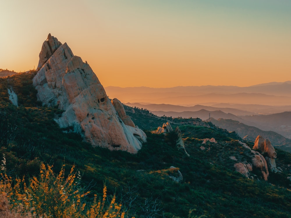 the sun is setting on a rocky mountain