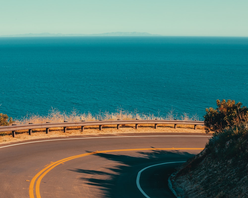 a curved road with a view of the ocean