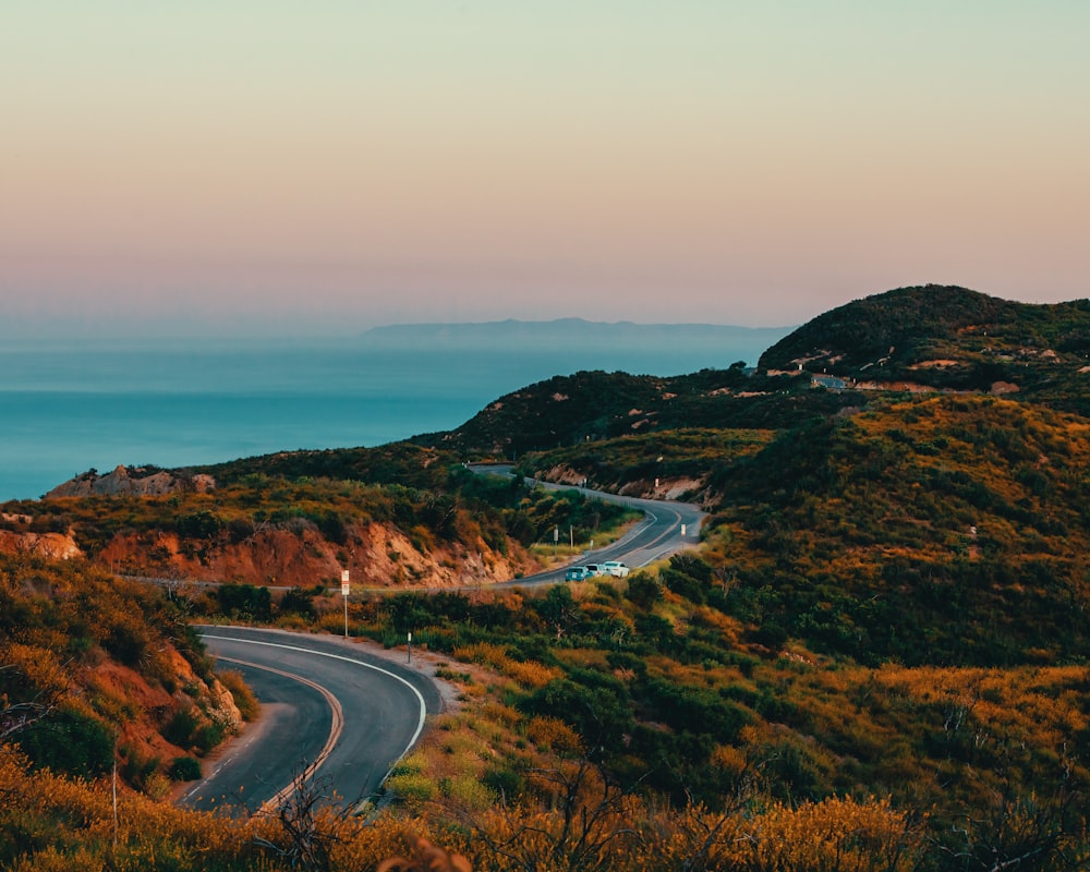 a winding road on a hill overlooking the ocean