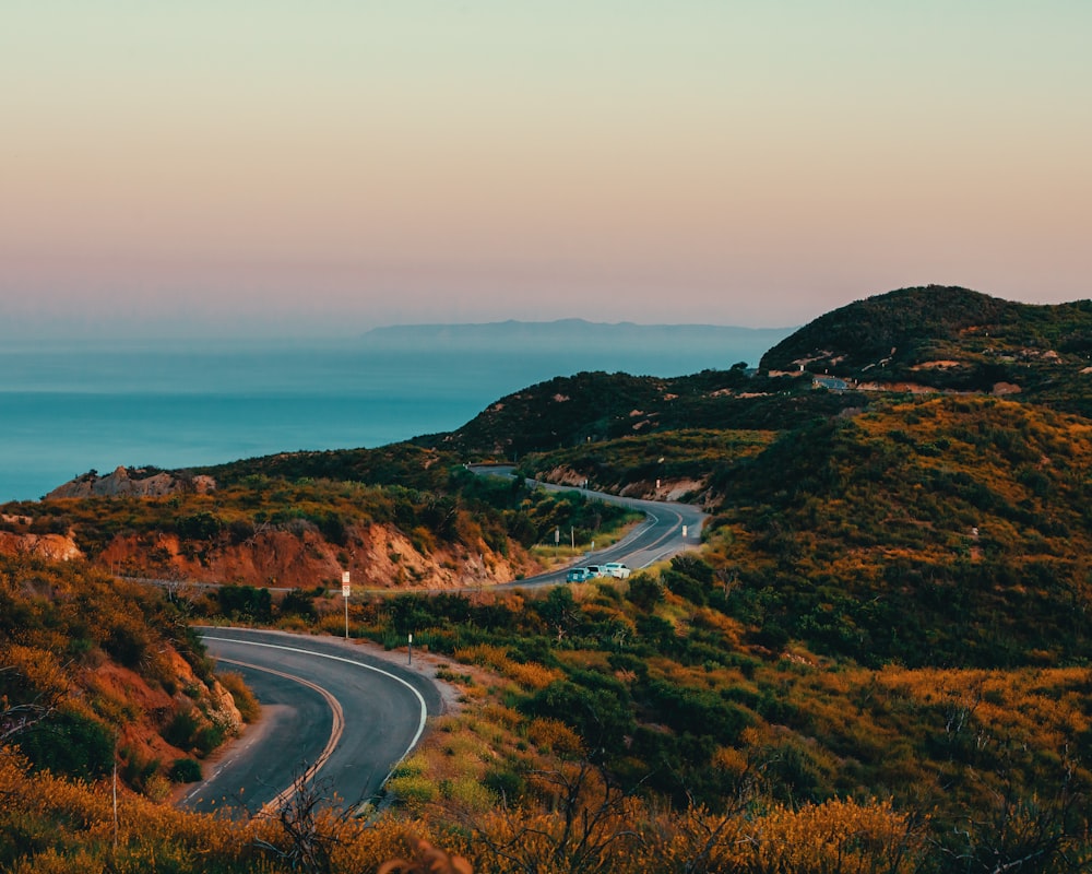 Un camino sinuoso en una colina con vistas al océano