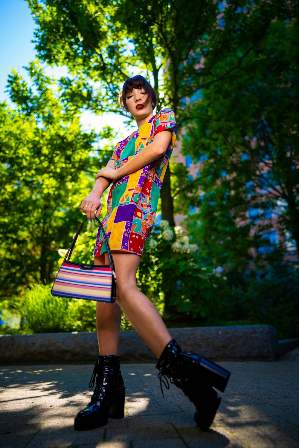 a woman in a colorful dress and black boots