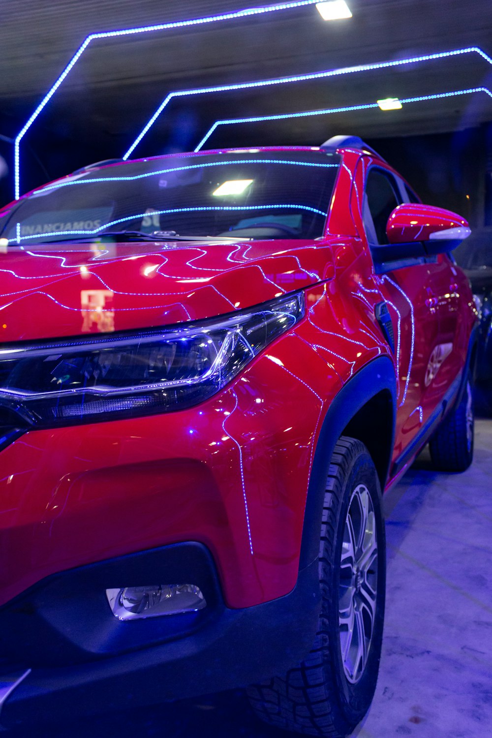 a red car is on display at a show