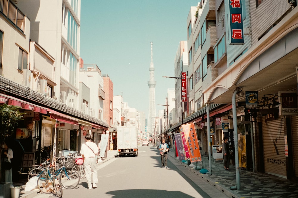 a person walking down a street next to tall buildings