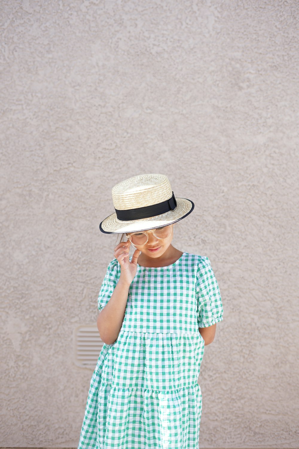 a woman in a green and white dress and hat