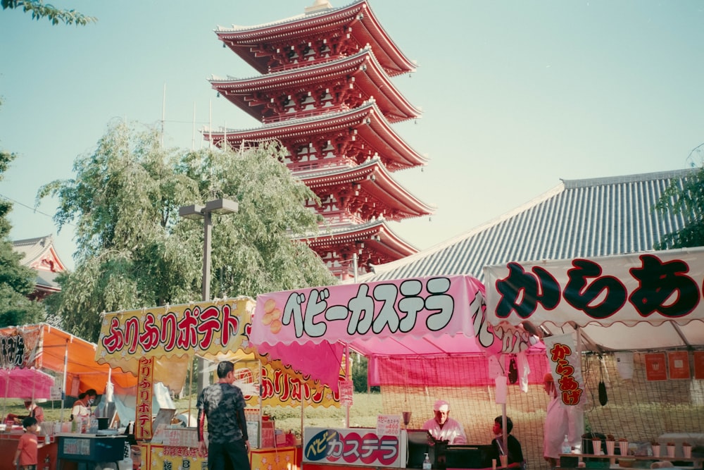 a woman standing in front of a food stand