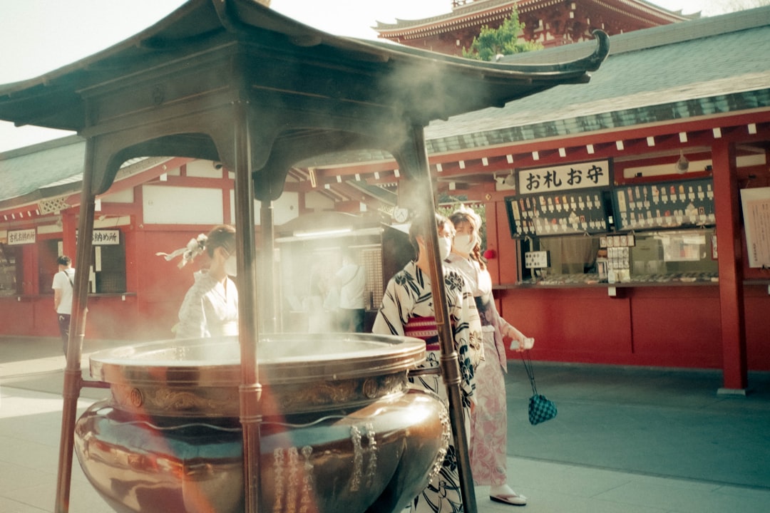 a group of people standing around a large pot,