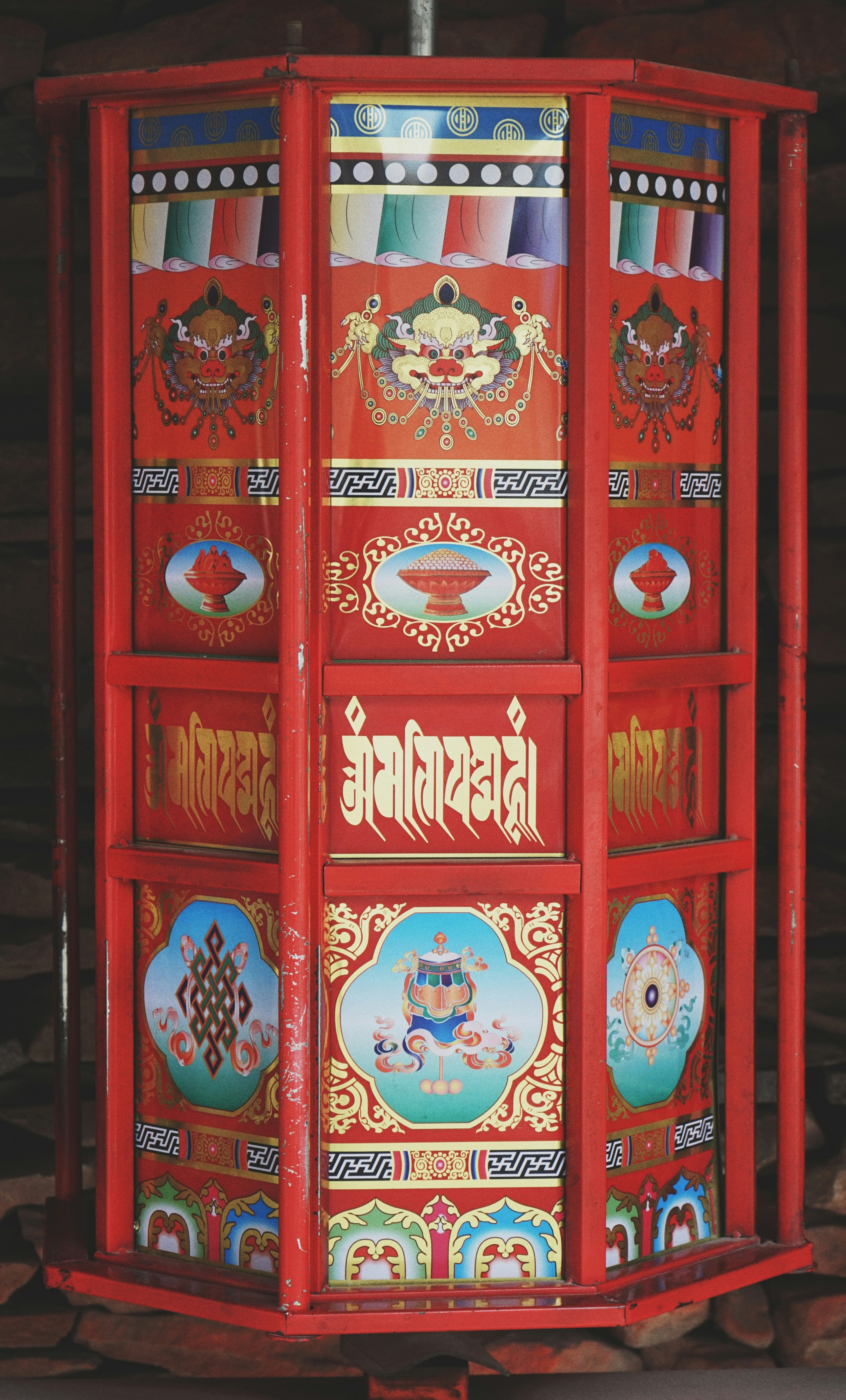 a colorfully painted cabinet is sitting on a pile of wood