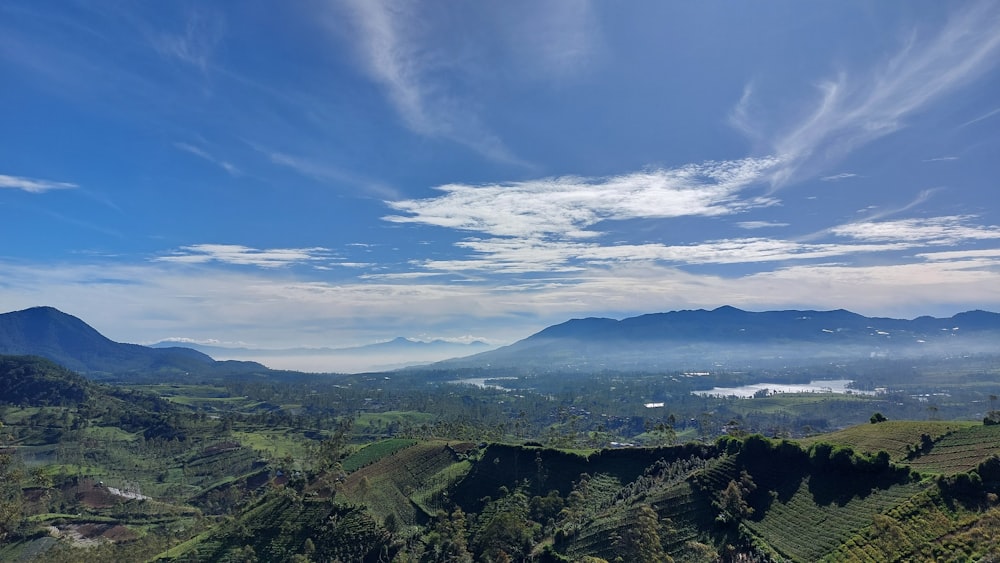 a scenic view of a valley with mountains in the background