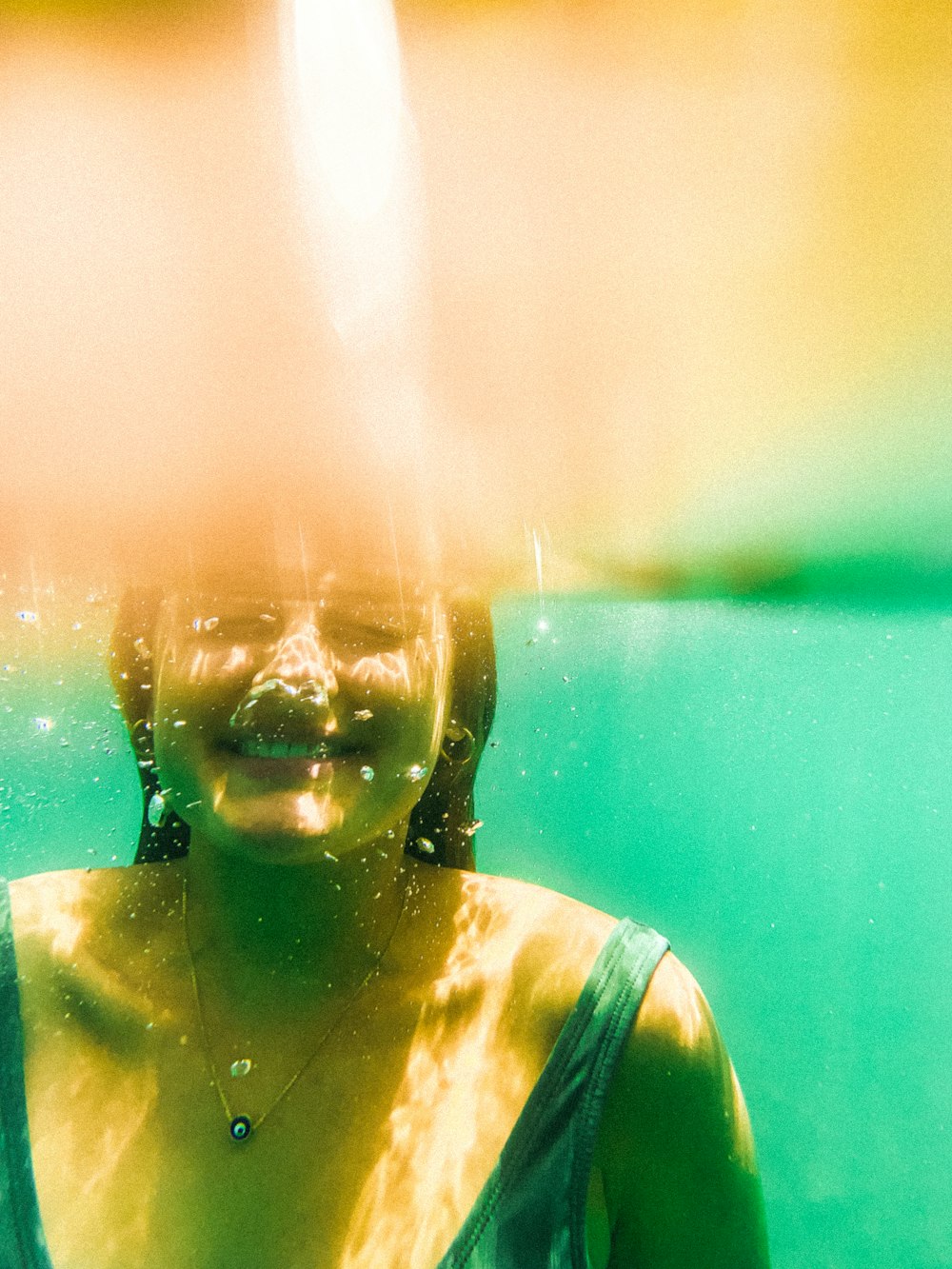 a woman under water with a smile on her face