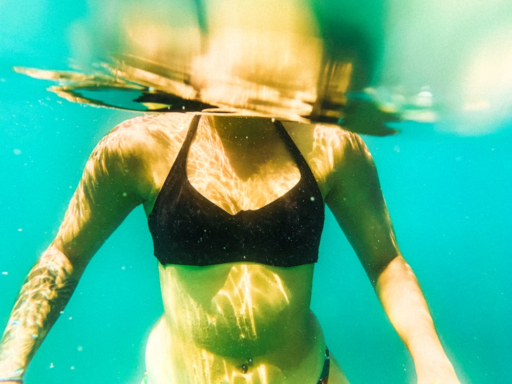 Une femme en bikini nage sous l’eau