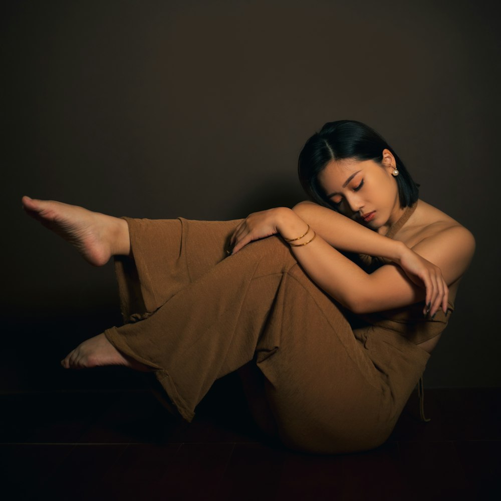 a woman sitting on the floor with her arms crossed