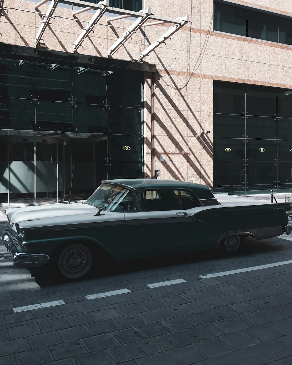 an old car is parked in front of a building