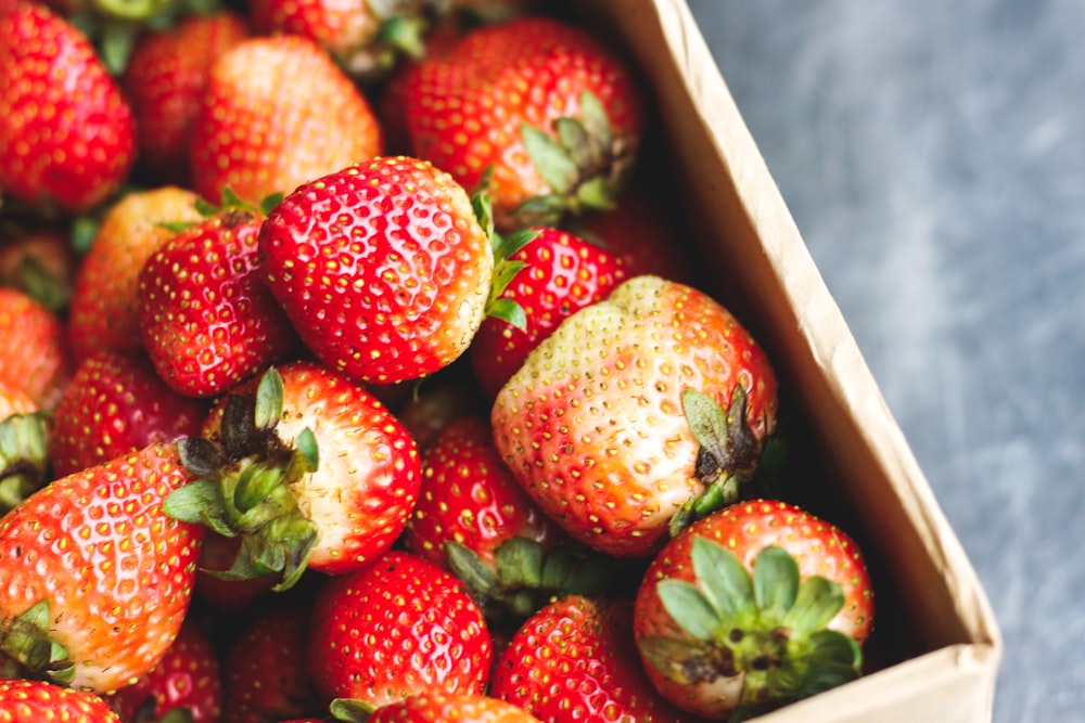 a box filled with lots of ripe strawberries