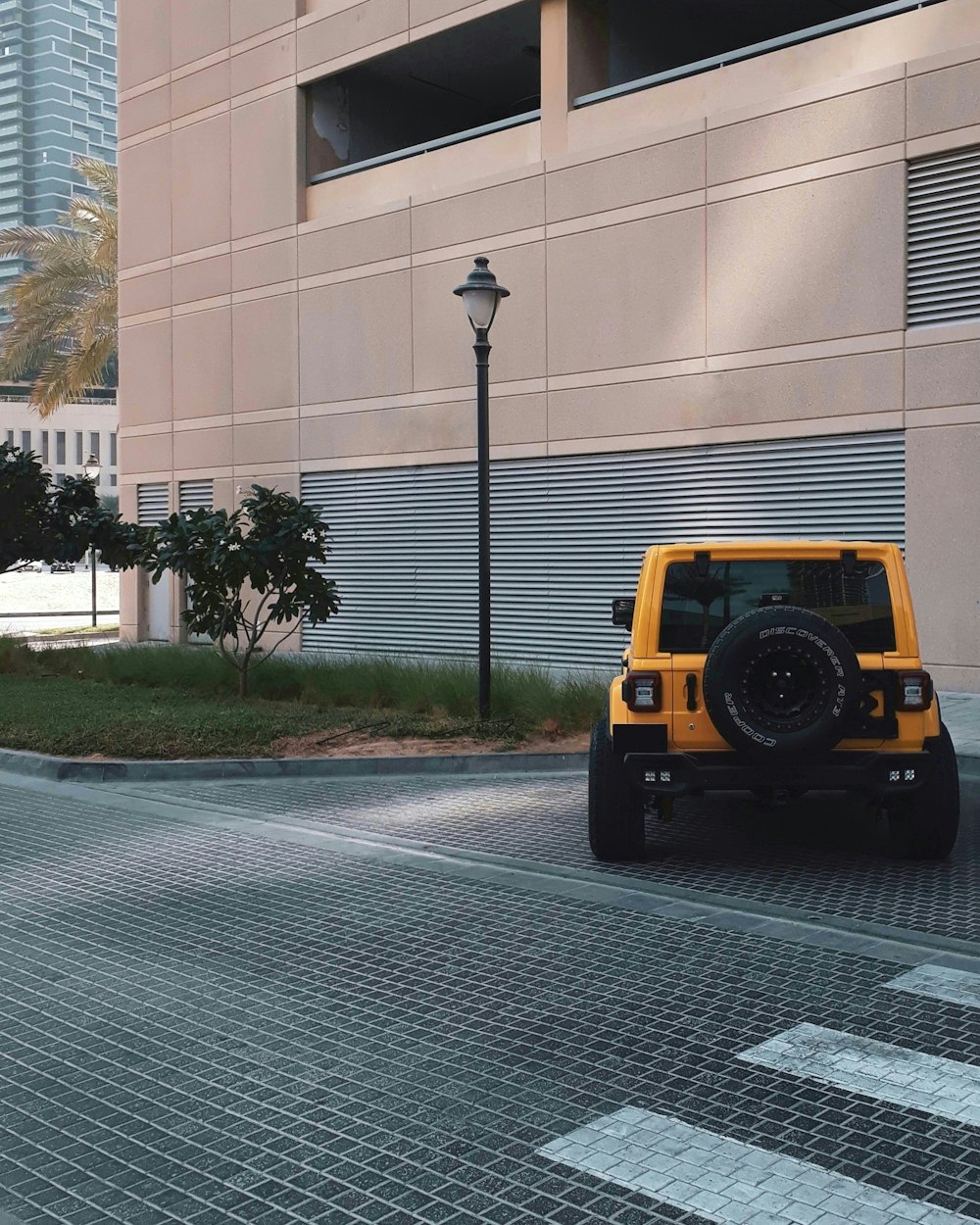 a yellow jeep parked in front of a building