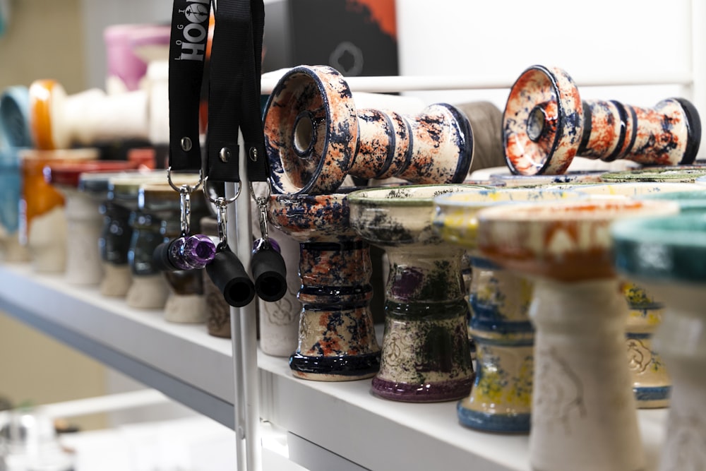 a row of vases sitting on top of a shelf