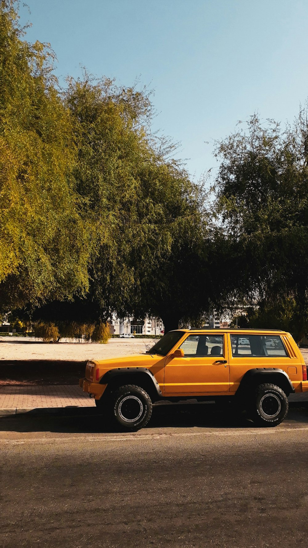 a yellow suv parked on the side of the road