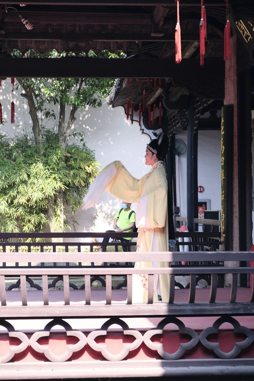 um homem vestido com roupas chinesas tradicionais segurando um guarda-sol