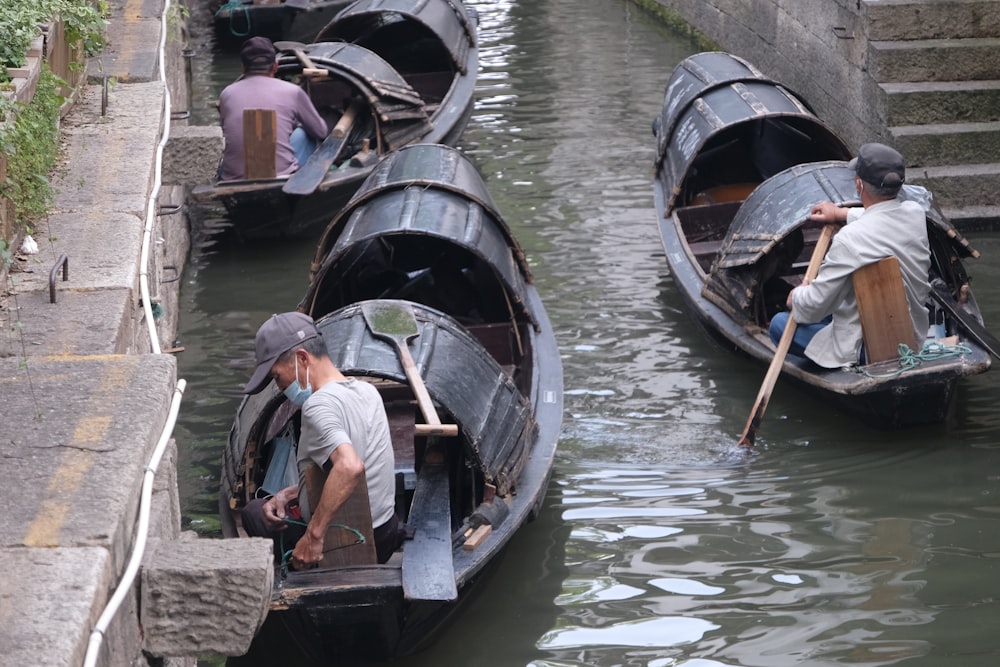 a group of people riding on top of small boats