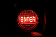 A flashy button labeled 'Entrar Ahora' blinking in neon red and gold.