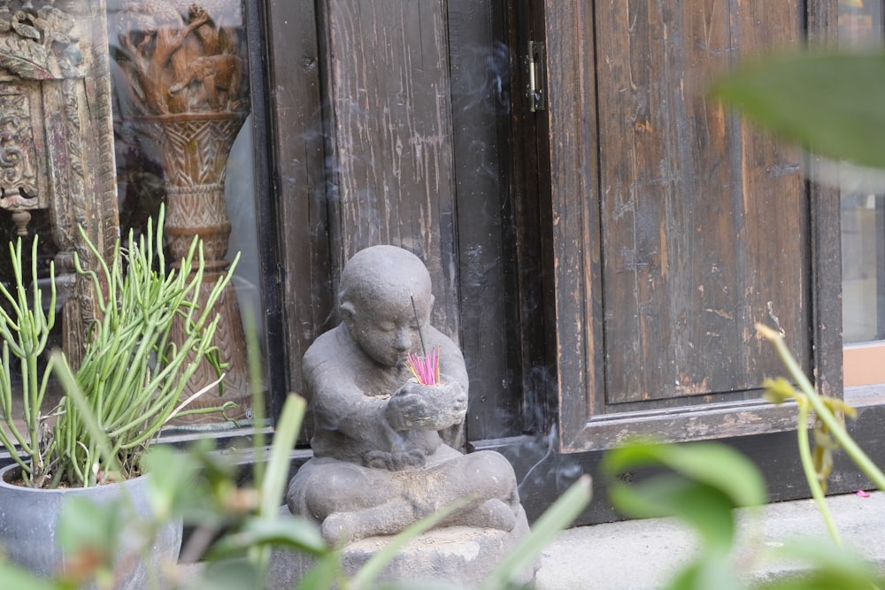 a statue of a baby sitting on top of a rock