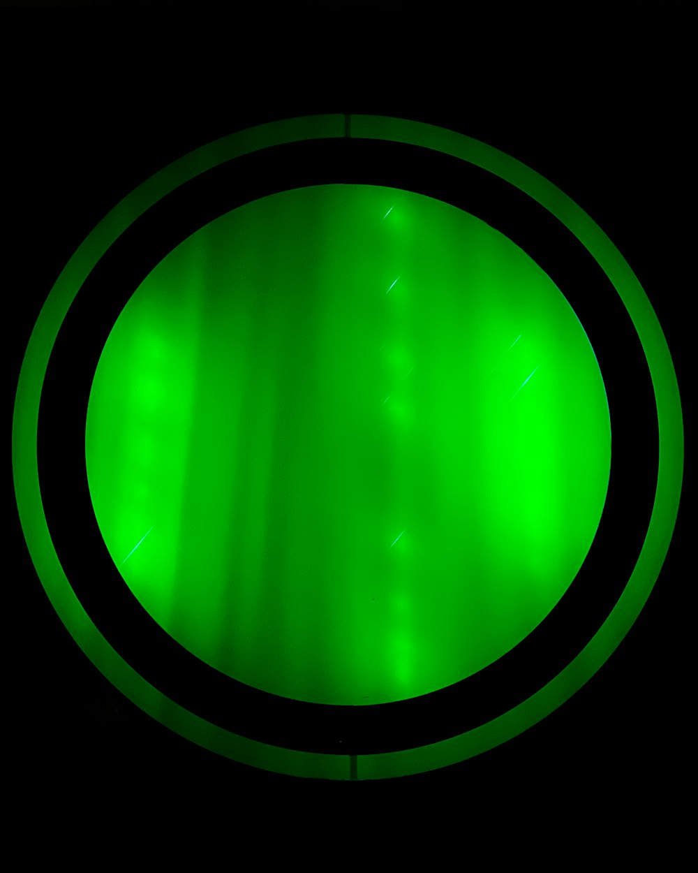 a close up of a green light in the dark