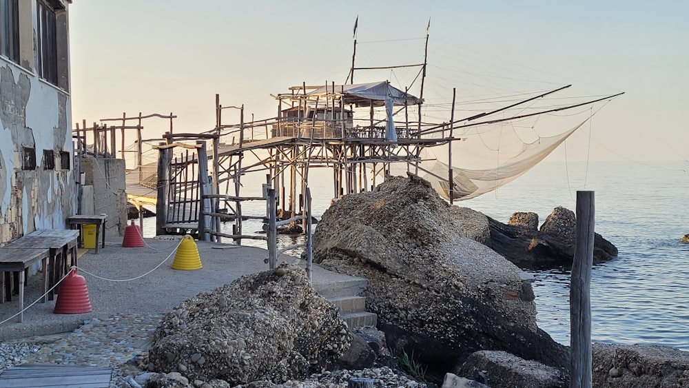 a building with a net on top of it next to a body of water