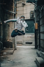 A dynamic shot of a young person running through a graffiti-filled alleyway wearing Lumina gear.