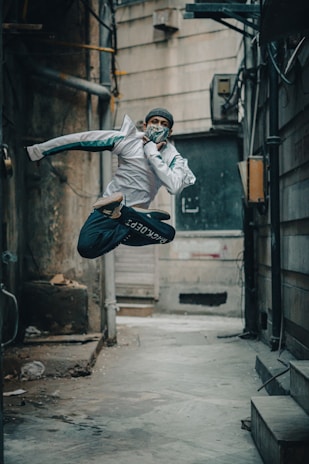 A dynamic shot of a young person running through a graffiti-filled alleyway wearing Lumina gear.