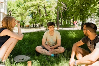 a group of people sitting in the grass