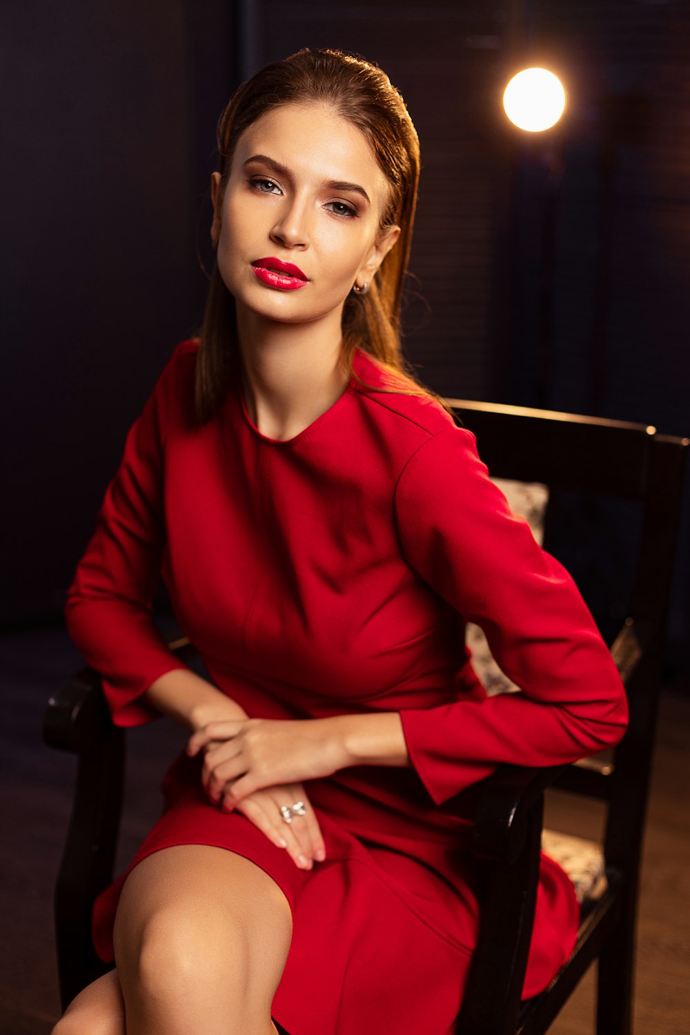 a woman in a red dress sitting in a chair