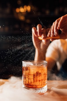 a person sitting in front of a glass filled with liquid