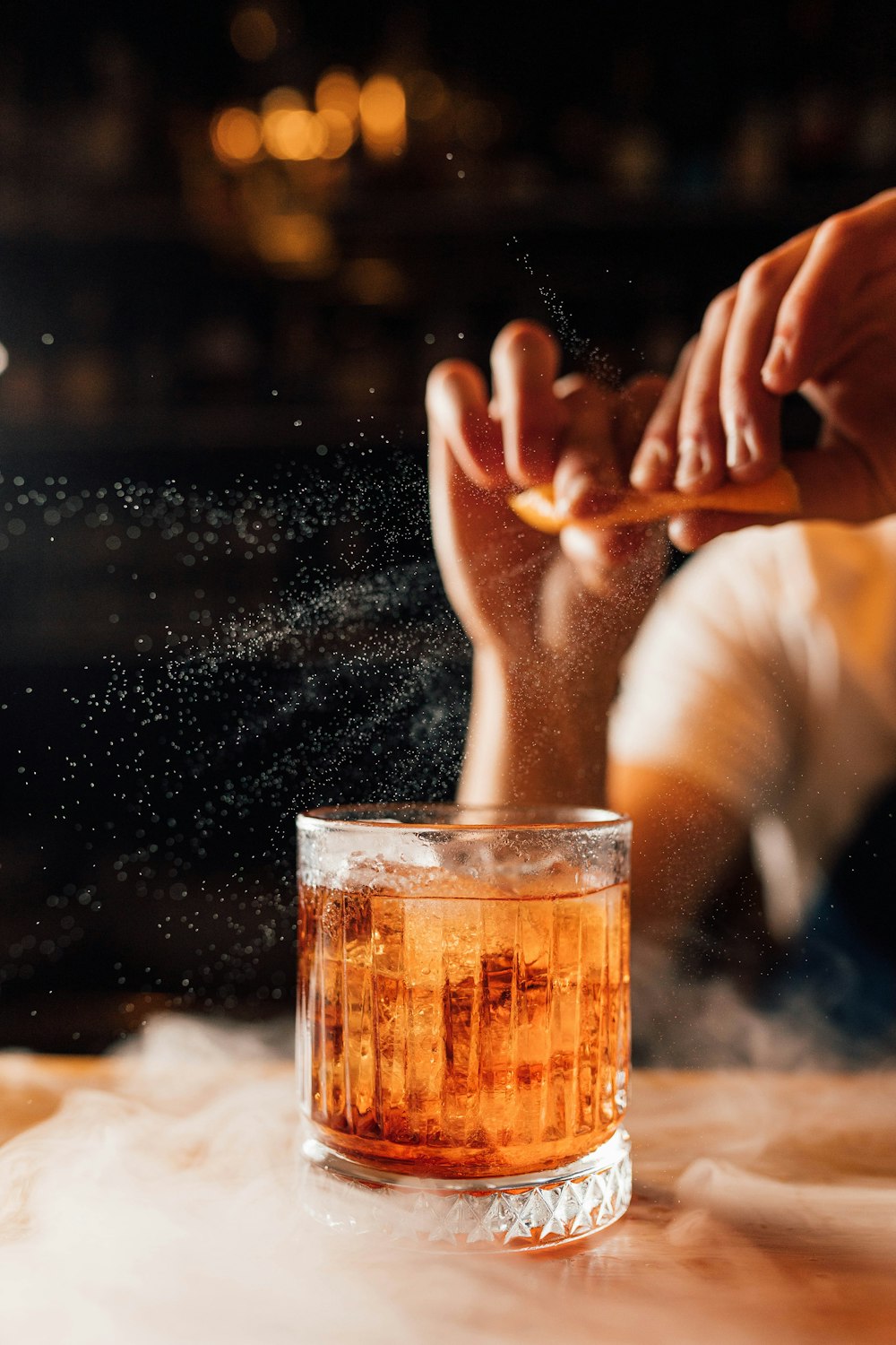 a person sitting in front of a glass filled with liquid