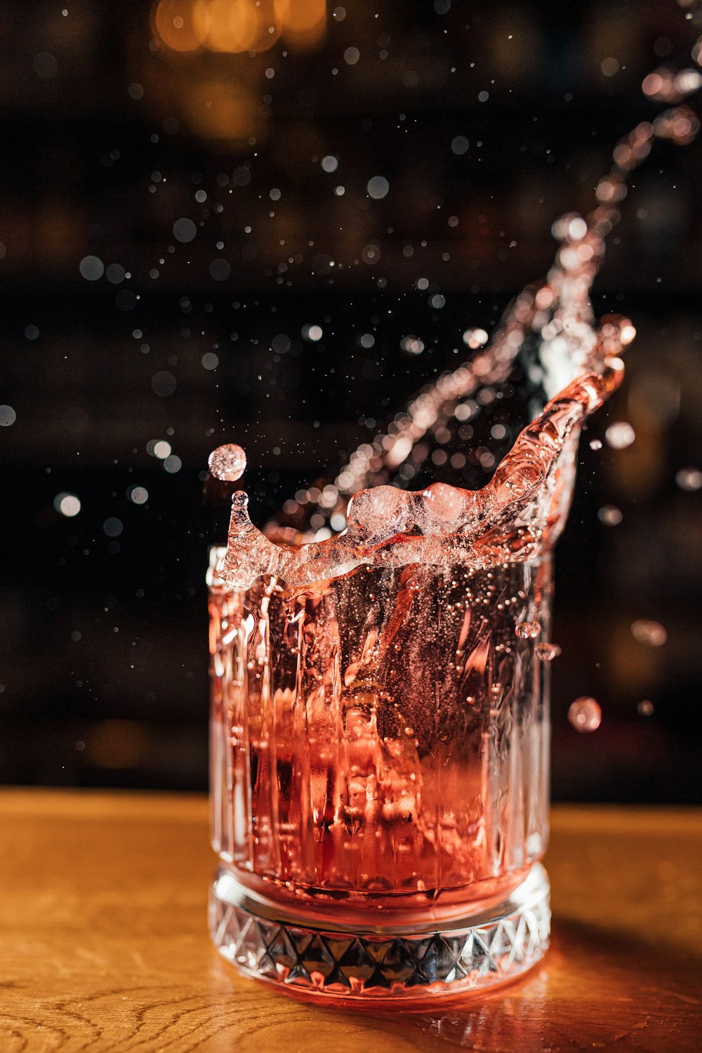 a glass filled with water on top of a wooden table