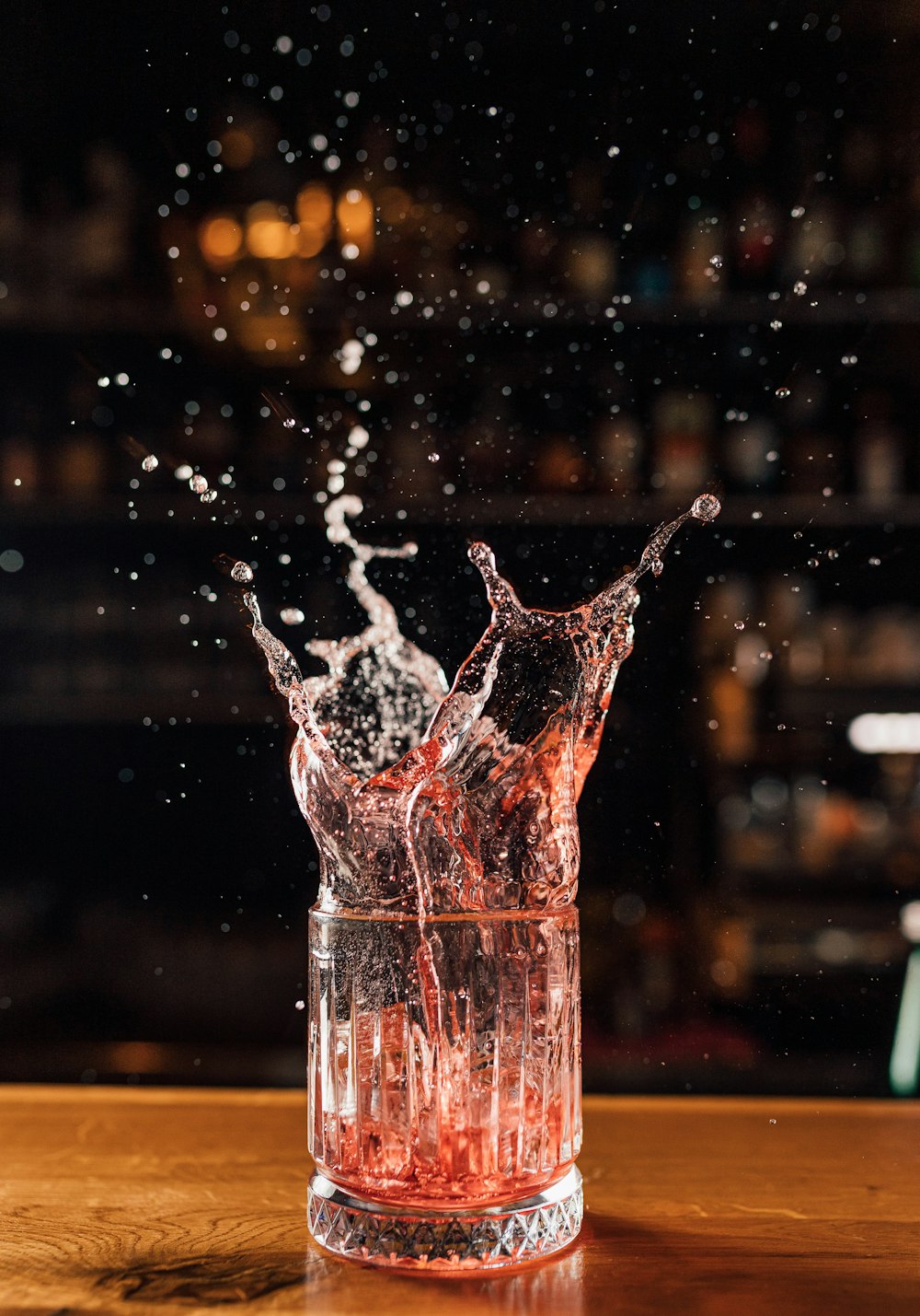 a glass filled with water on top of a wooden table