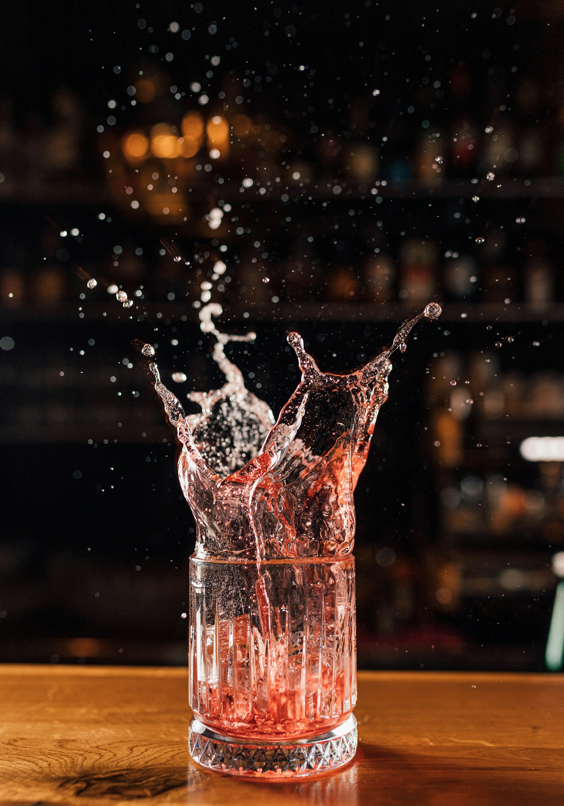 a glass filled with water on top of a wooden table