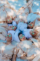 a group of people laying on top of a bed covered in sheets