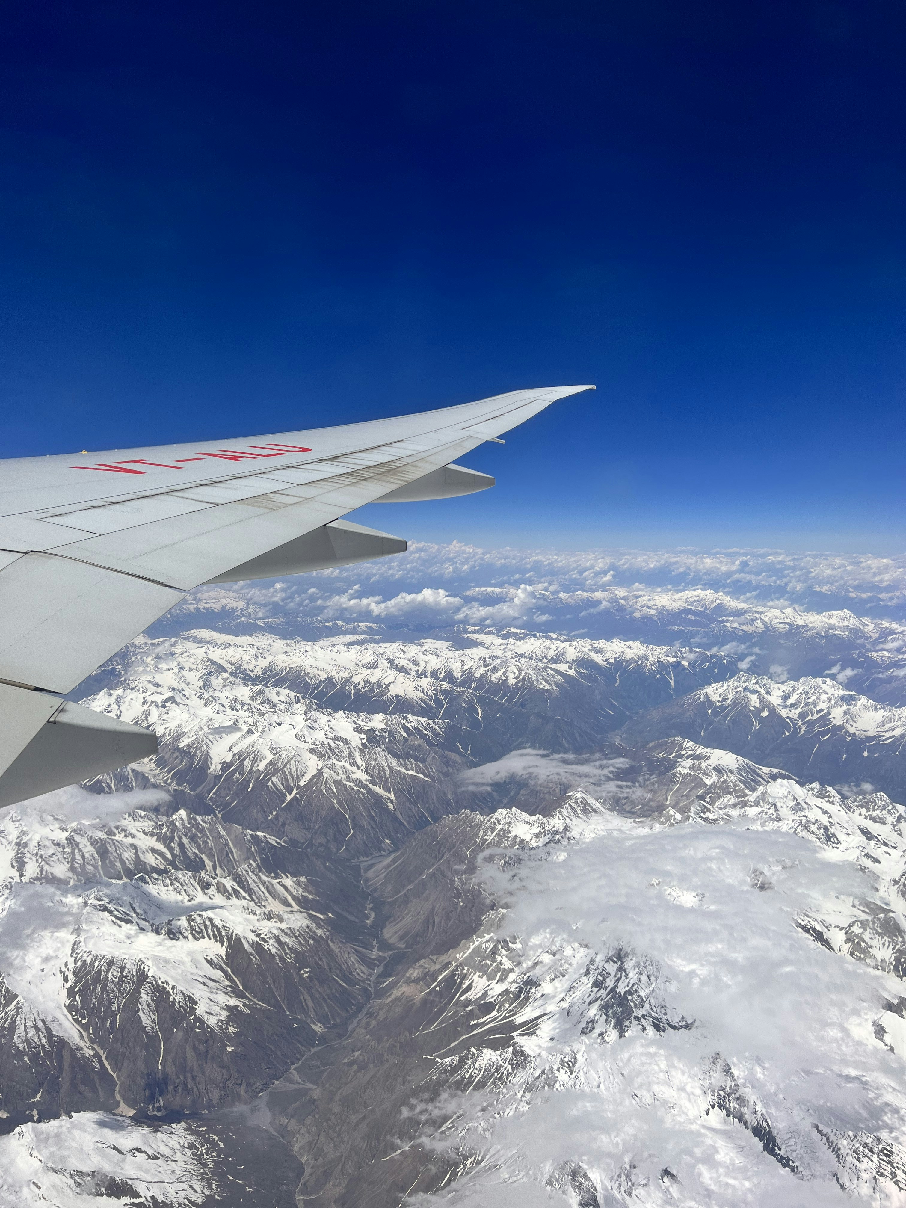 the wing of an airplane flying over a mountain range