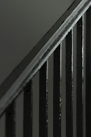 Close-up of sturdy welded joints on a silver metal staircase railing.