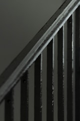 Close-up of a sturdy metal handrail with brushed finish on a staircase.