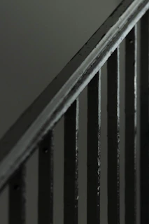 Close-up of a sleek, custom-cut steel staircase railing with a brushed finish