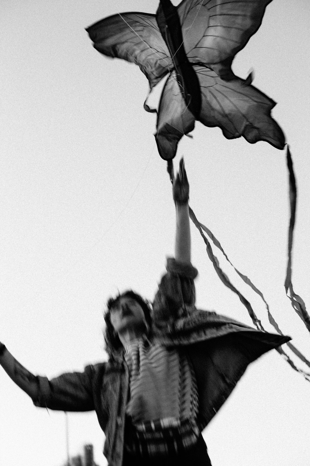 a woman flying a butterfly kite in the sky