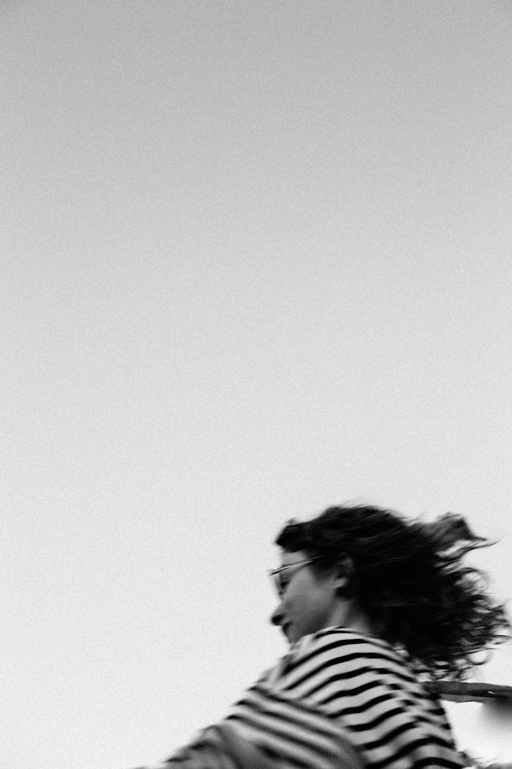 a woman in striped shirt flying a kite