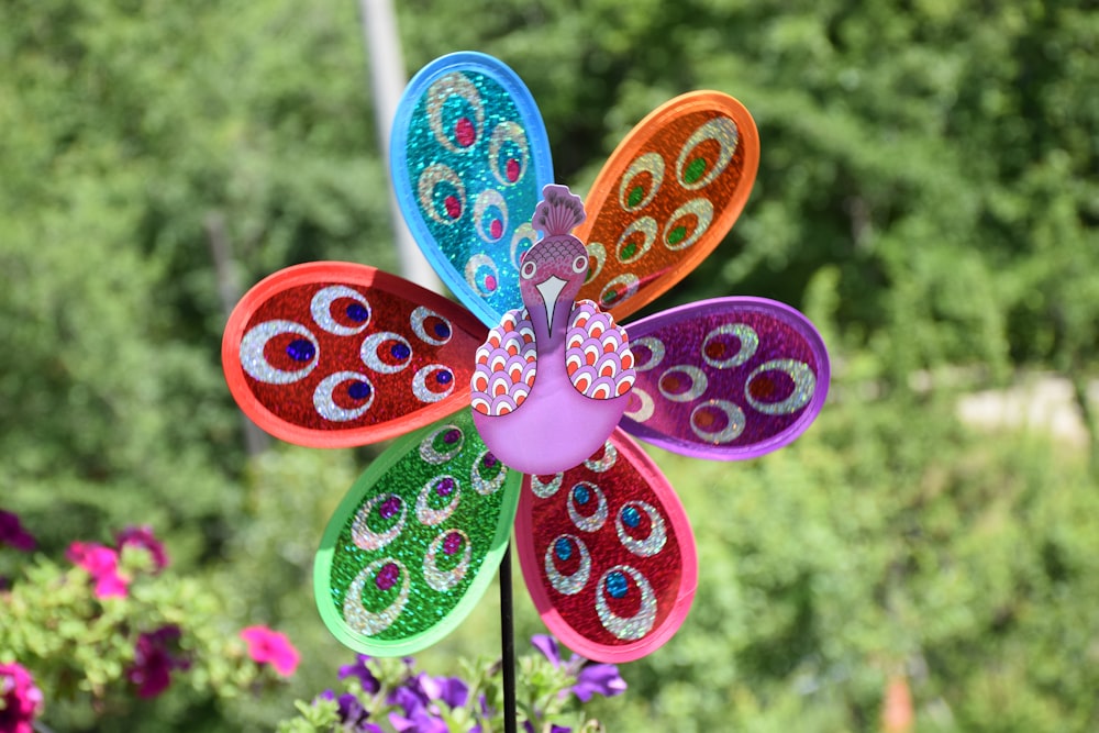 Un fiore colorato fatto di carta seduto in un giardino