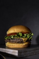 Stack of juicy hamburgers with melted cheese and fresh lettuce, perfectly arranged.